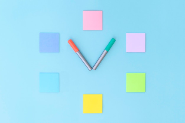 Clock made of colorful stickers and markers on blue background