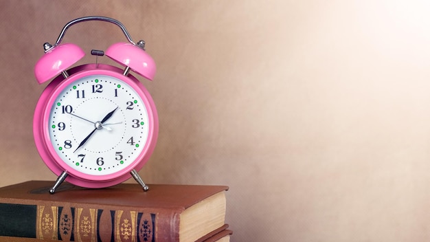 Clock on a stack of books copy space