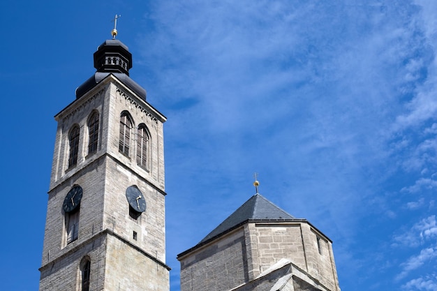 A clock tower of the catholic church against the blue sky on sunny day with copy space