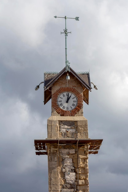 Photo clock tower on a cloudy sky background closeup