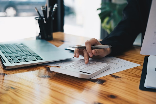 Close up a accountant working about financial with calculator at his office to calculate expenses, Accountigng concept.