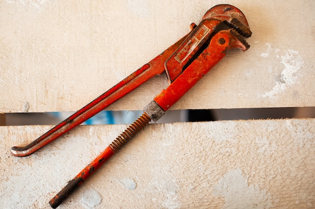 Close-up of adjustable gas wrenches of red color on wooden table.