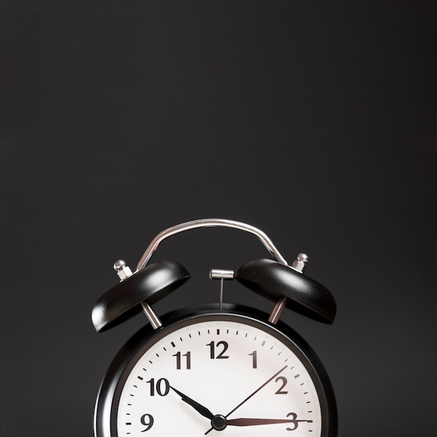 Close-up of a alarm clock against black background