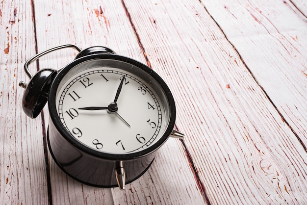 Close-up of alarm clock on a wooden tabletop