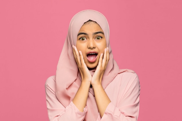 Close-up of amazed happy young Asian woman with open mouth