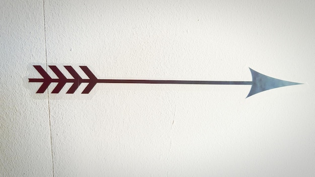 Photo close up of an arrow print on white wall