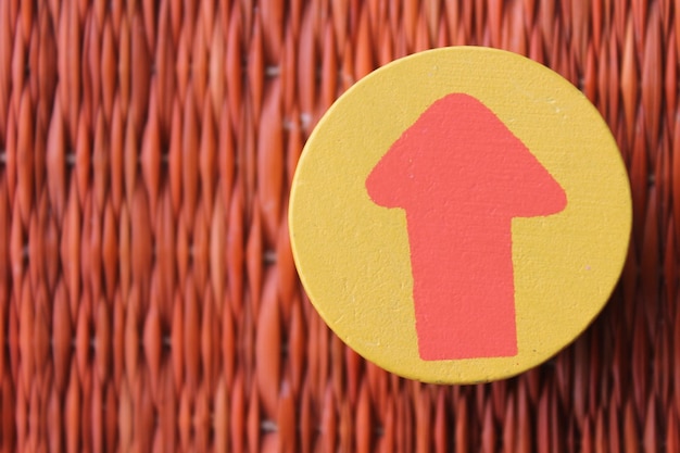 Photo close-up of arrow sign on patterned wall