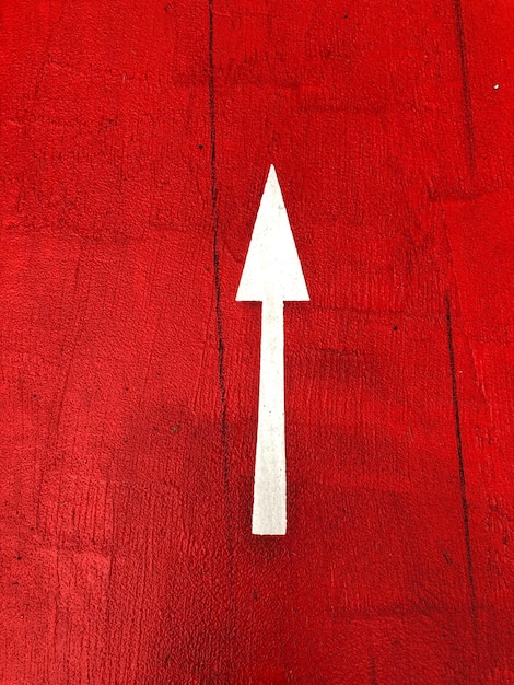 Photo close-up of arrow sign on red wall