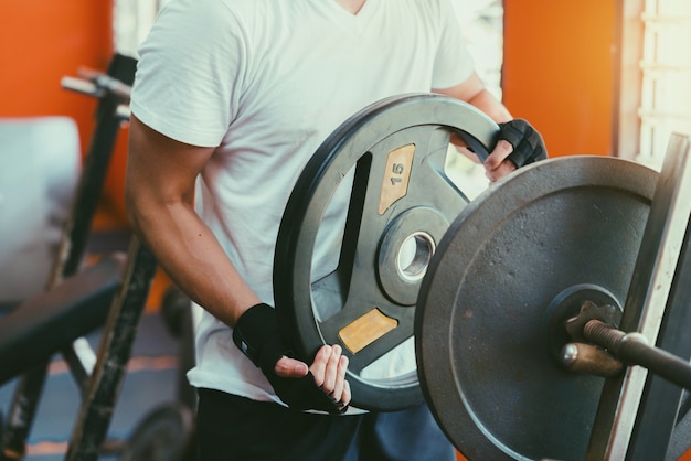 Close up of  asia man hand holding weight indoor gym