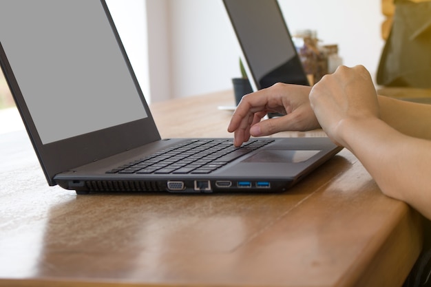 Close-up of Asia's woman working on laptop while sitting at the coffee shop