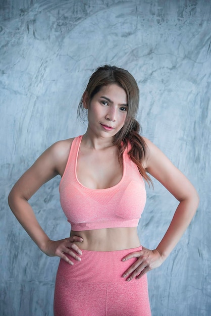 Close up asian beautiful sport girl on wall of gymThailand love healthSlim woman workout concept