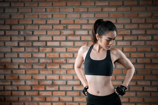 Close up asian beautiful sport girl on wall of gymThailand love healthSlim woman workout concept