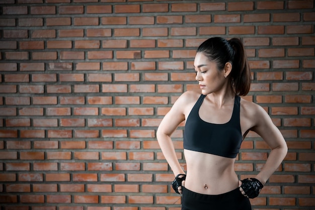 Close up asian beautiful sport girl on wall of gymThailand love healthSlim woman workout concept