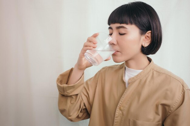 Close up asian woman drink water from a glass of water