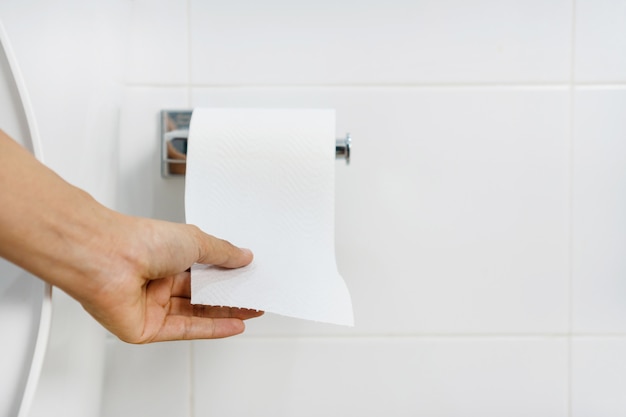 Close up of Asian woman hand  pulling paper in bathroom