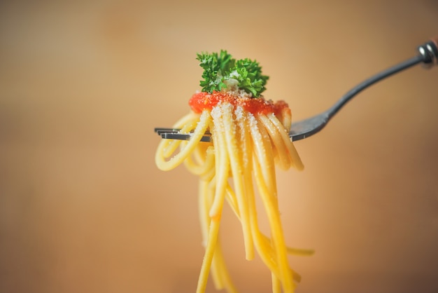 Close-up of asta spaghetti with tomato sauce, olives and garnish. Italian food.