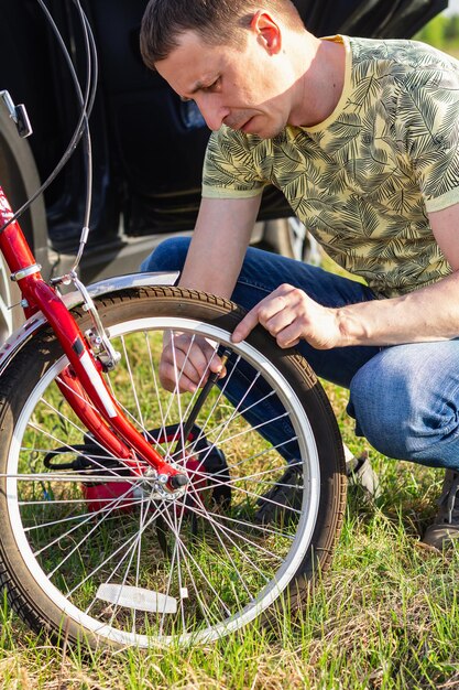 Close up of attractive adult man Handsome Bike Mechanic pumping up bicycle wheel World Bicycle Day