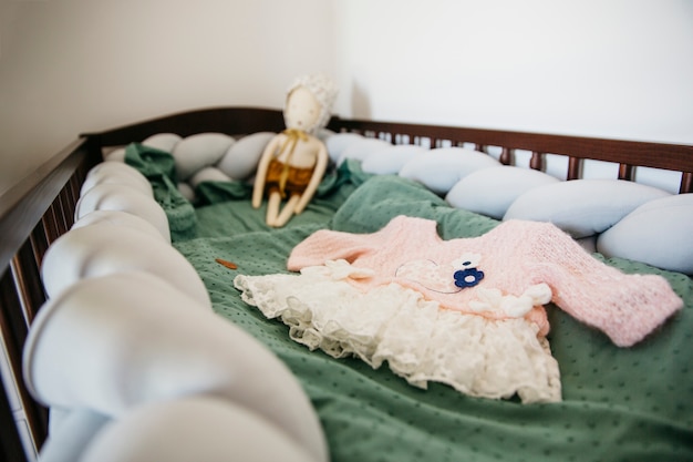 Close-up of baby dress with doll in the crib