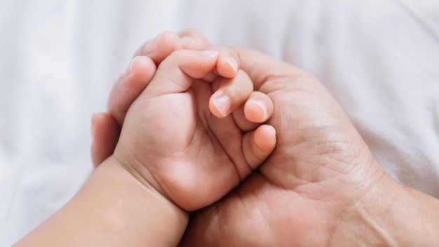 Close up baby hand on mother's handsxA