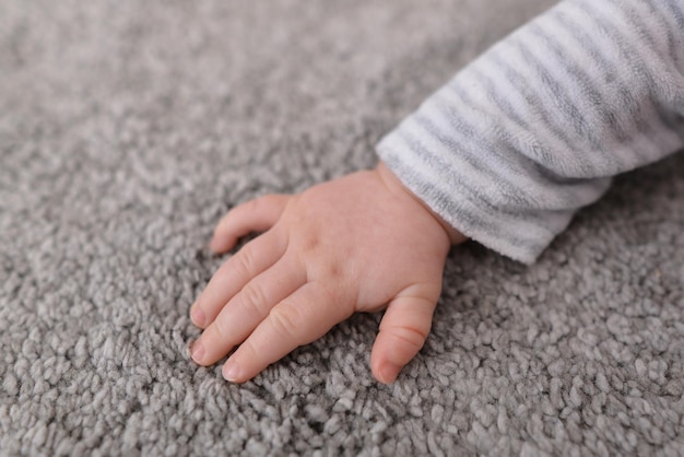 Close up of baby hand touching soft carpet Gentle and fluffy carpet between fingers