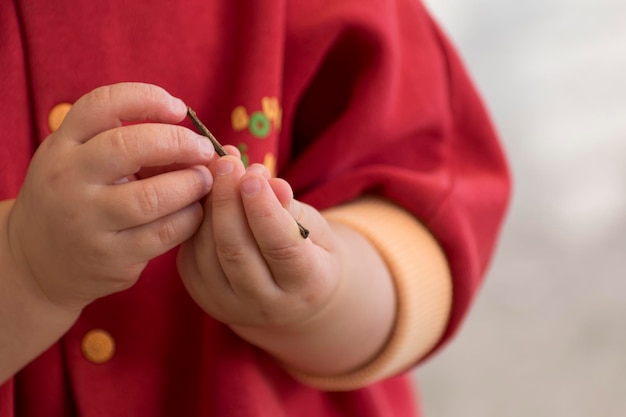 Close up of a baby's hands playing with a twig outside activity fine motor skills development