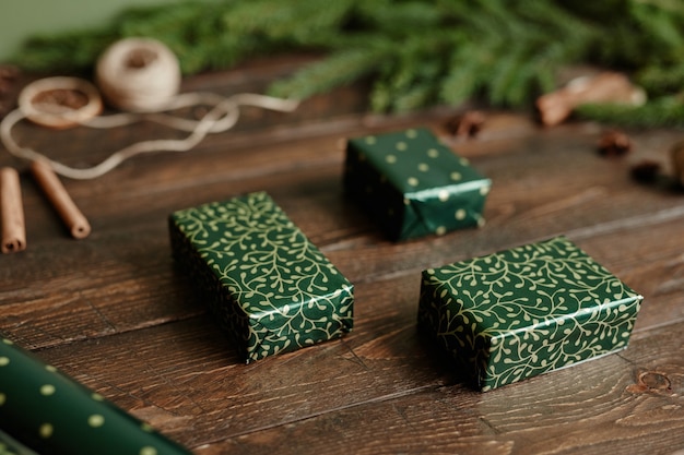 Close up background image of elegant christmas presents wrapped in green paper on rustic wooden tabl...