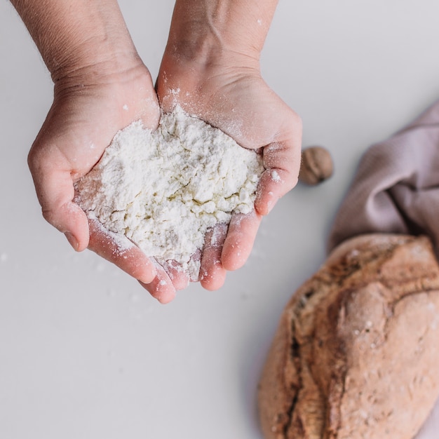 Close-up of a baker's hand holding flour