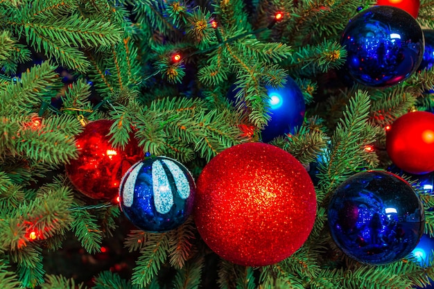 Close up of balls on christmas tree Bokeh garlands in the background New Year concept