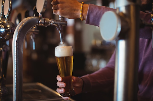 Close-up of bar tender filling beer from bar pump