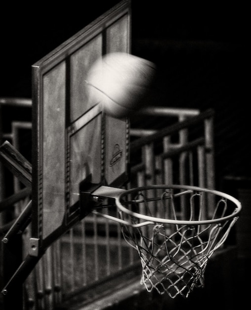 Photo close-up of basketball hoop with ball in motion