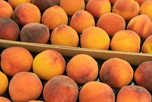 Close up beatiful fresh raw peaches in a wooden crate