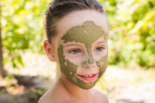     Close up of beautiful girl with facial clay mask 