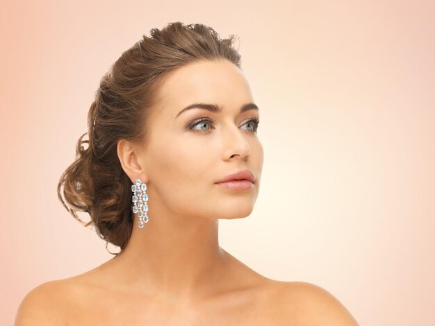 close up of beautiful woman wearing shiny diamond earrings