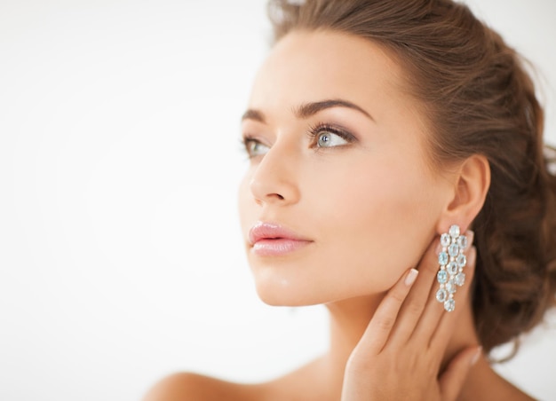 close up of beautiful woman wearing shiny diamond earrings