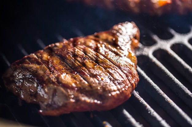 Close-up Beef flank steak cooking on grill.