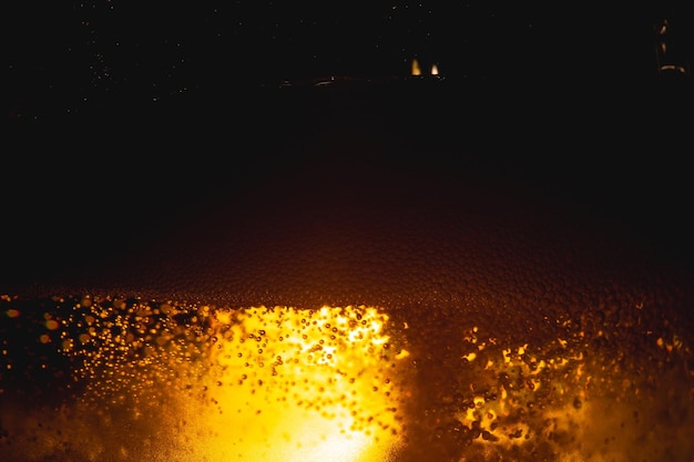 Close up of the beerClose up in foam and bubbles of beer on black backgroundWater drops background