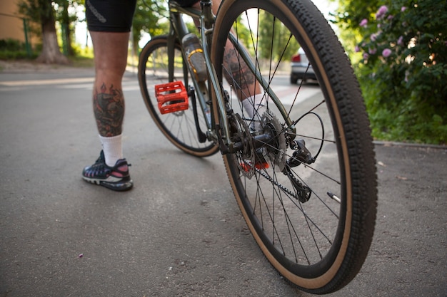 Close up of a bicycle wheel, man cycling in the city