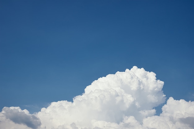 Close up of big white fluffy cloud on clear blue sky