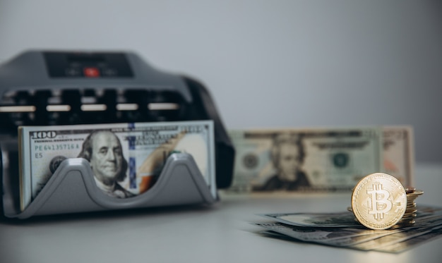 Close up of bitcoin crypto currency coins and american dollar banknotes. USA dollars. Money background. Crypto currency golden bitcoin coin