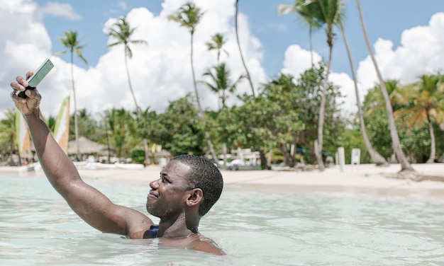 Close up black man taking selfie in sea