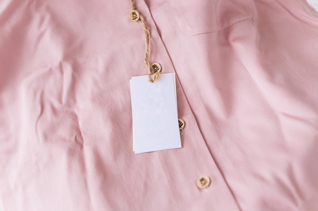 Close-up blank tag label on pink shirt. Copy space. space for advertisement.