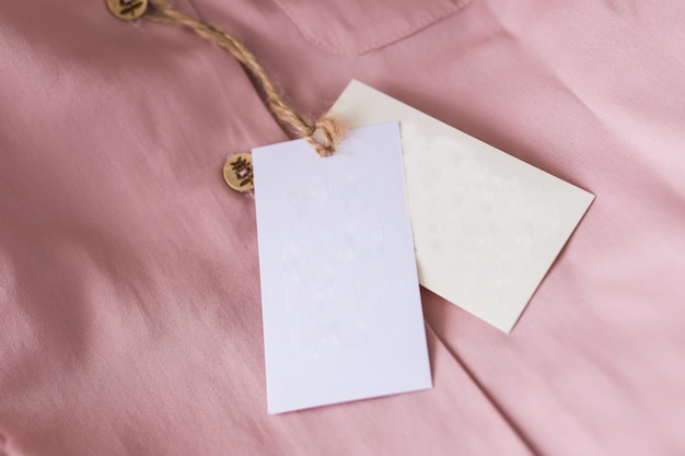 Close-up blank tag label on pink shirt. Copy space. space for advertisement.