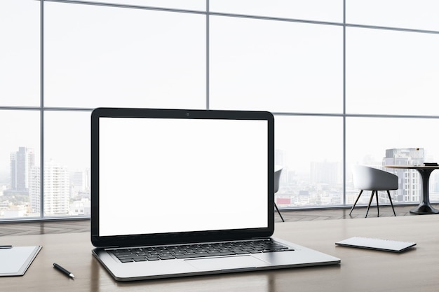 Close up of blank white laptop computer screen on wooden office desktop with supplies on panoramic window and city view background Mock up 3D Rendering