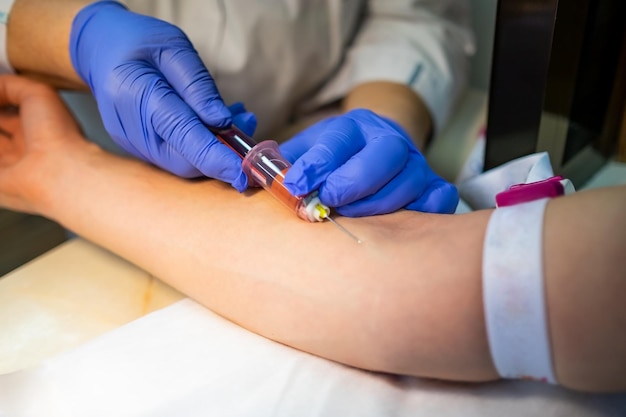 Close up blood test from vein taking by doctor on the table