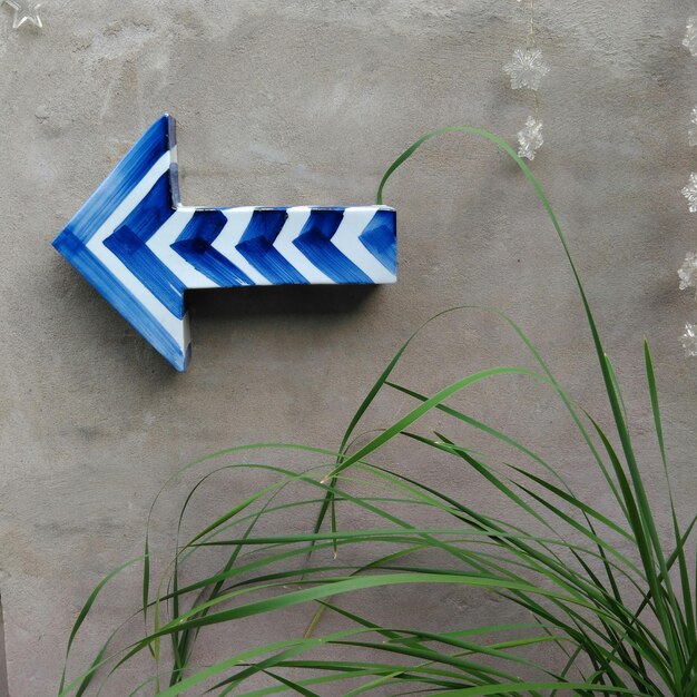 Photo close-up of blue arrow symbol mounted on wall