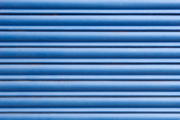 Close up of a blue metal curtain protecting a closed shop or house