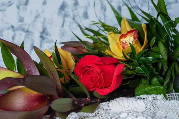 Close up bouquet with one red rose and orchids