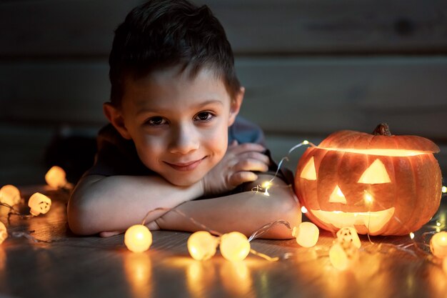 Close up on boy lies next to the pumpkin