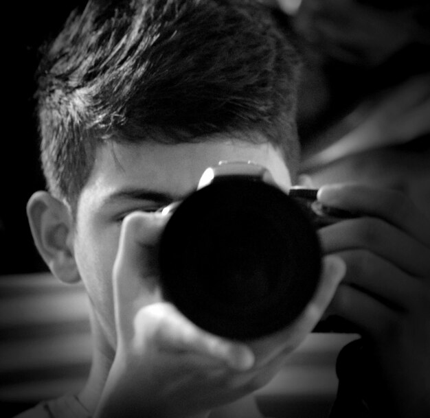 Close-up of boy photographing through camera