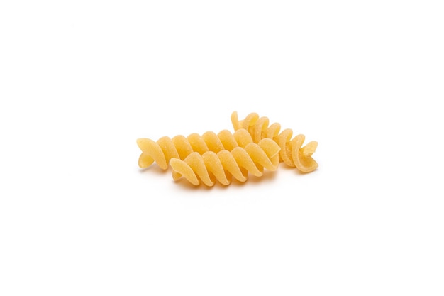 Close up bright yellow uncooked Fusilli pasta on white background.